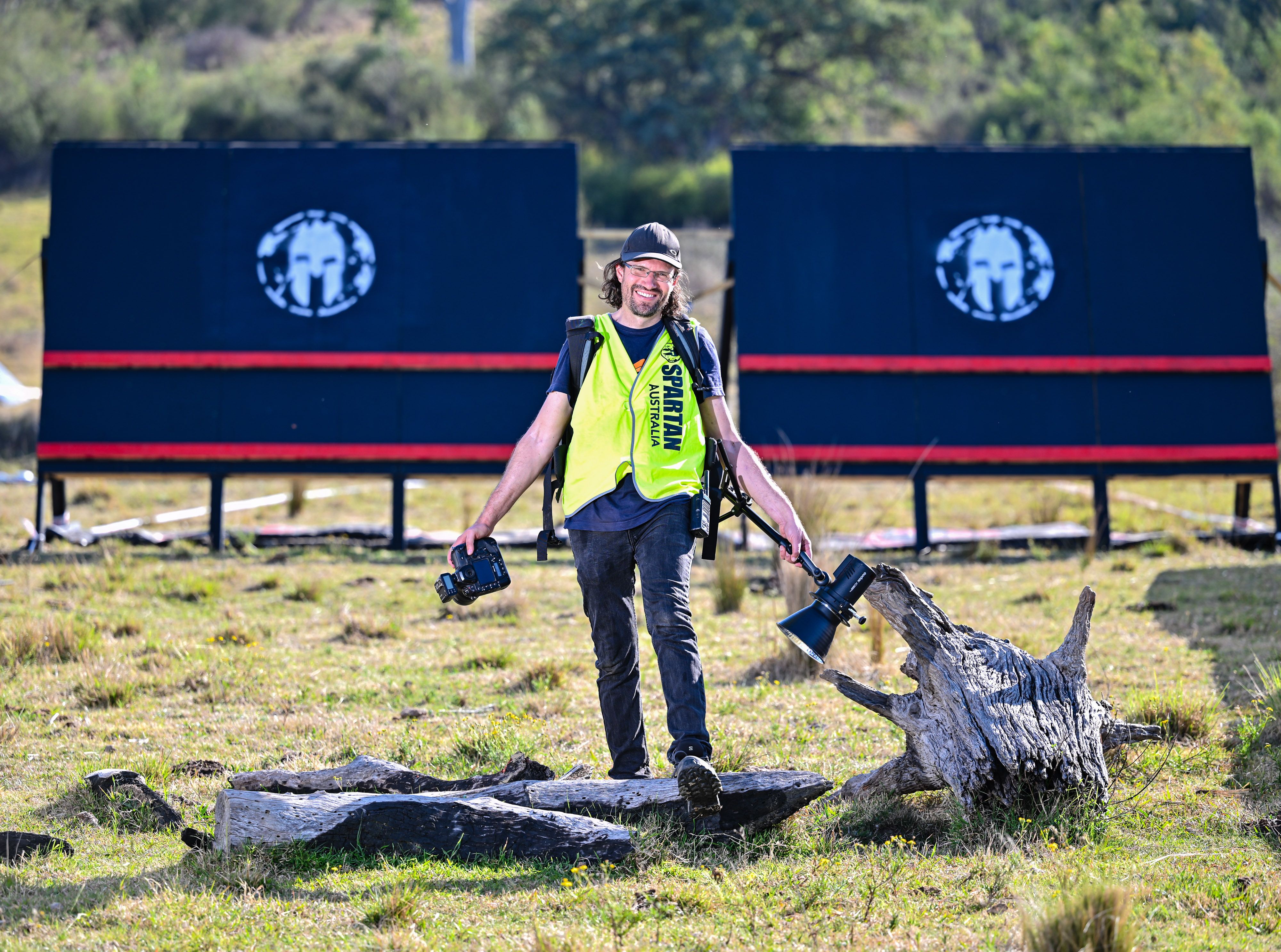 Scott walking across an event course carrying photography equipment